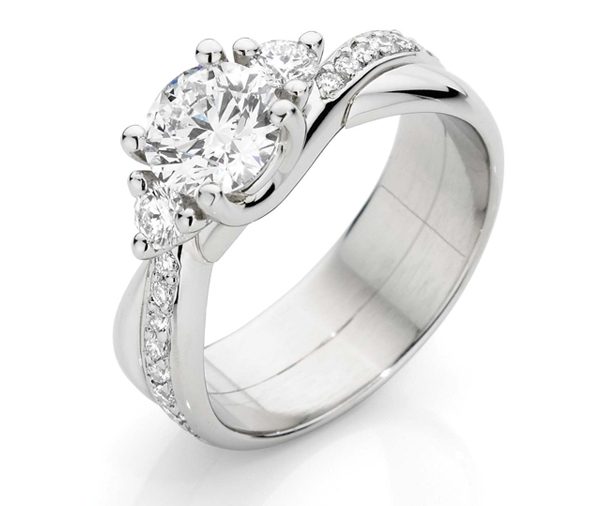 Round trilogy diamond ring with larger centre diamond on a cross over grain set diamond and plain band