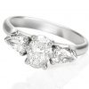white gold trilogy engagement ring with oval diamond claw set in-between a pair of pear shape diamonds