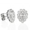 white gold studs featuring a bezel set pear cut diamond surrounded by scallop set small diamonds